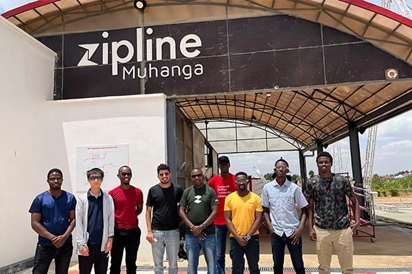 Group picture in front of Zipline sign