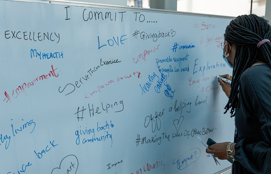 Student writing on board at Giving CMU Day