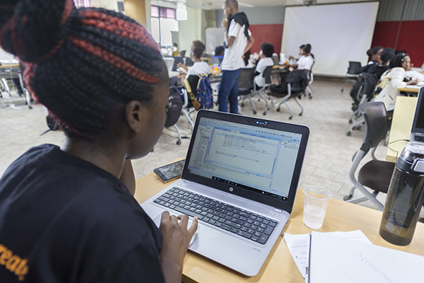 student working on a laptop in a classroom