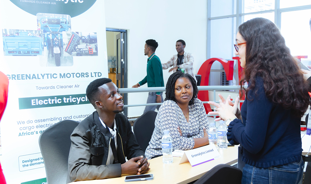 A company's table at the summit with two people interacting