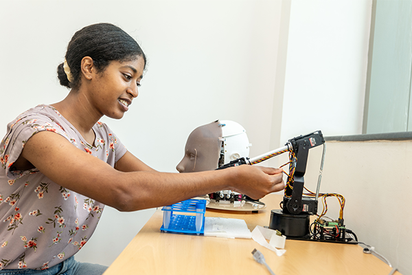A woman working at a table on a robotic head