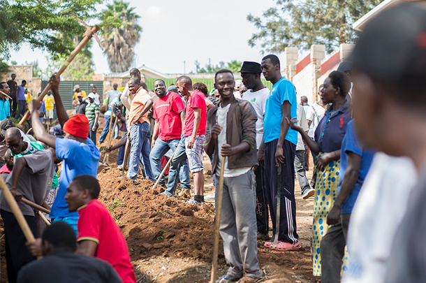 Students work together to dig drain