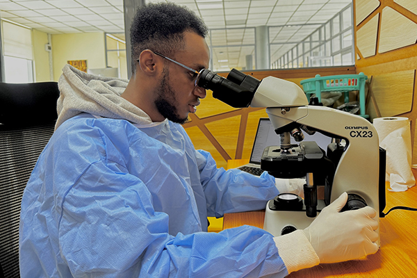 A student looking into a microscope