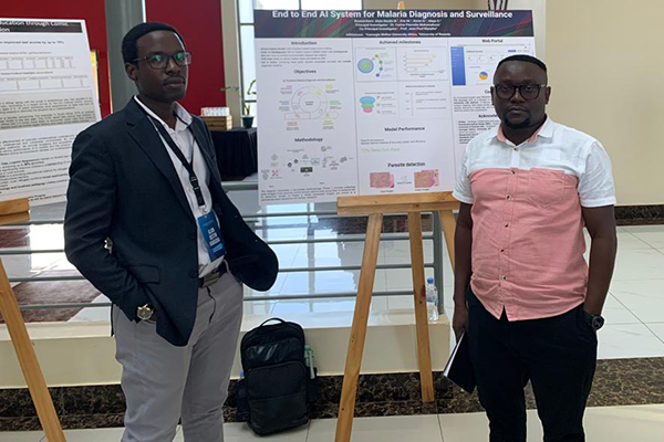 Two students in front of their poster