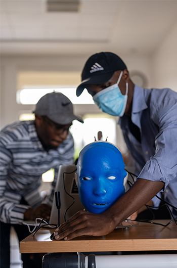 Two people working on a robotic head