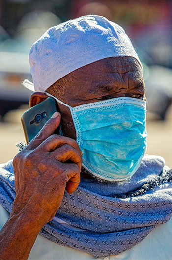 Man on phone in Africa wearing mask